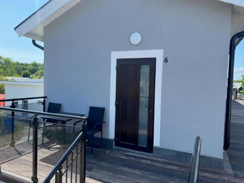 a white house with a black door and a balcony at Solberga lägenhetshotell in Köpingsvik
