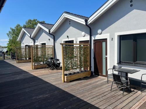 a deck with a table and chairs on a house at Solberga lägenhetshotell in Köpingsvik