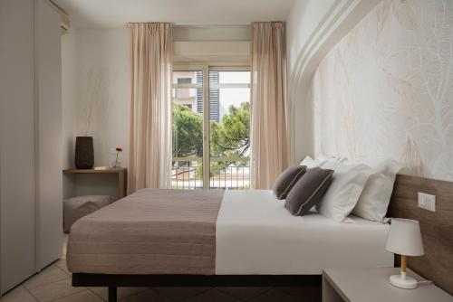 una camera da letto con un letto grande con una finestra di Hotel Parco a Milano Marittima