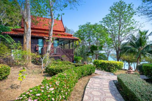 a house with a red roof and a walkway at Phi Phi Natural Resort in Phi Phi Don