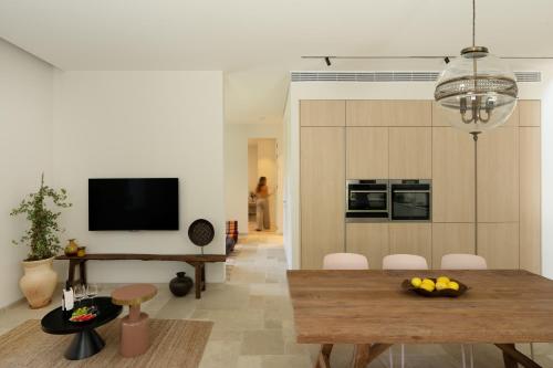 a living room with a dining table and a television at THE Y HOUSE in Jerusalem