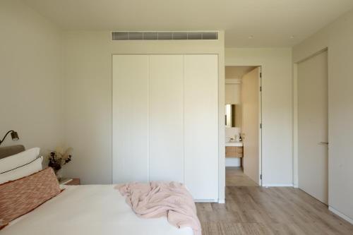 a bedroom with a white bed and a white wall at THE Y HOUSE in Jerusalem