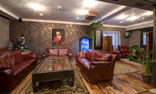 a living room with leather furniture and a christmas tree at Hotel Galileo Donovaly in Donovaly