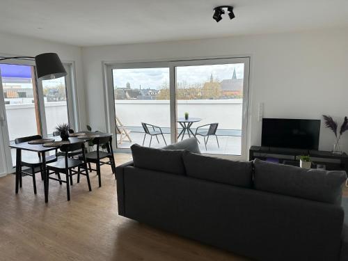 ein Wohnzimmer mit einem Sofa und einem Tisch in der Unterkunft Ostwall Terrassen Apartment 5.29 in Bocholt