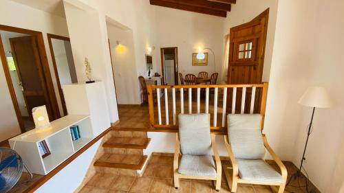 sala de estar con 2 sillas y escalera en Villa Cristina, en Binibeca
