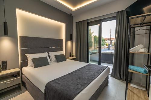 a bedroom with a large bed and a balcony at Assos Luxury Villas in Pefkochori