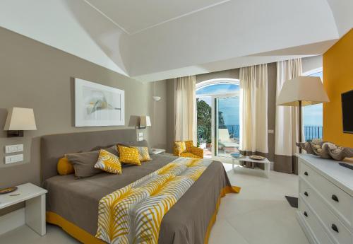 ein Schlafzimmer mit einem großen Bett und einem Balkon in der Unterkunft Hotel Della Piccola Marina in Capri