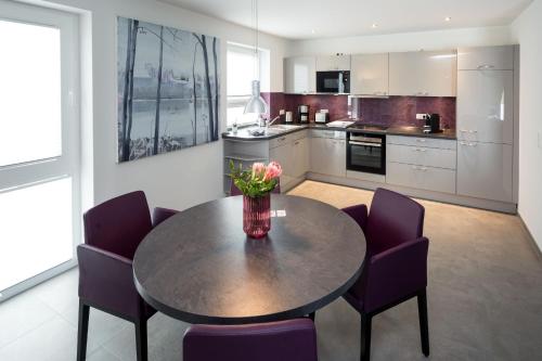 a kitchen with a table with chairs and a vase of flowers on it at VILLA MON BIJOU _ OG_Fewo in Göhren-Lebbin