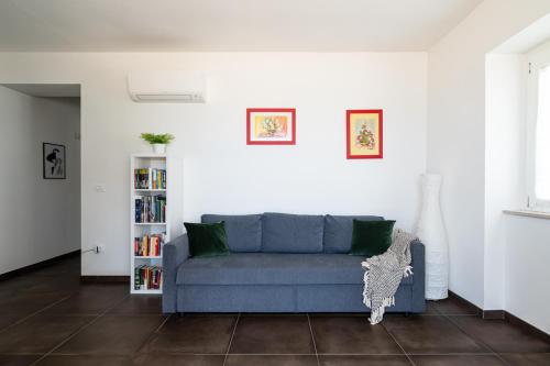 un soggiorno con divano blu e libreria di Ostriche - YourPlace Abruzzo a Torino di Sangro