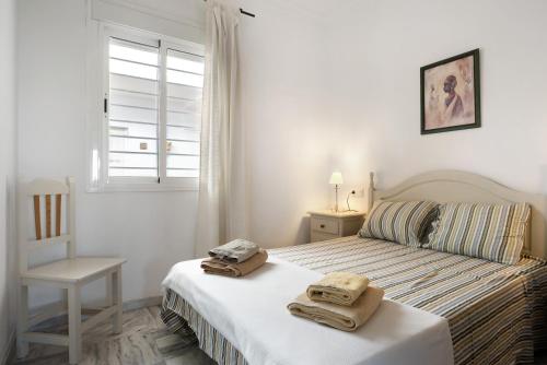 een slaapkamer met een bed met handdoeken erop bij Casa María in Conil de la Frontera
