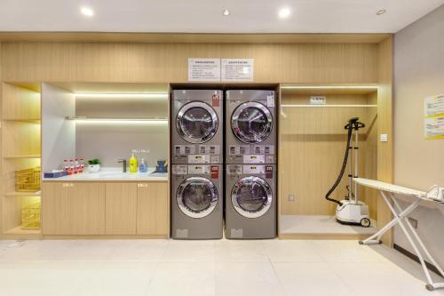 two washing machines are in a laundry room at Qianhai Holiday Hotel in Bao'an