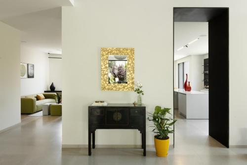 a living room with a table and a painting on the wall at THE Y HOUSE in Jerusalem