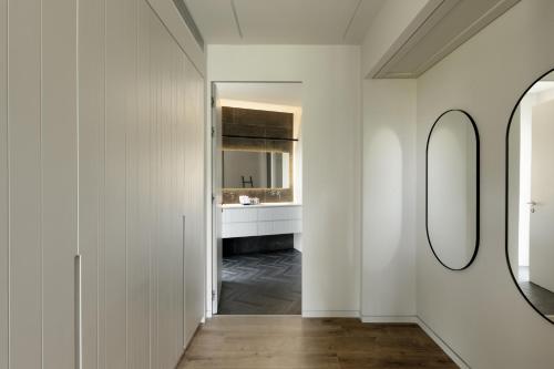 a hallway with white walls and two mirrors at THE Y HOUSE in Jerusalem