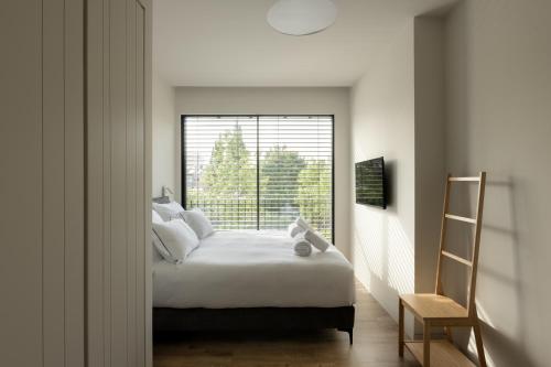 a bedroom with a bed and a large window at THE Y HOUSE in Jerusalem