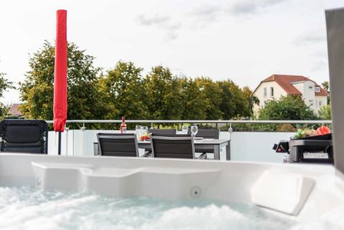 a bath tub with chairs and a table on a balcony at Luxus_SPA_OG_Fewo DREAMTIME _WE 3_ in Göhren-Lebbin