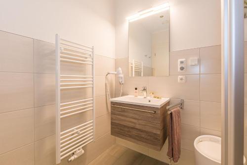 a white bathroom with a sink and a mirror at Luxus_SPA_OG_Fewo DREAMTIME _WE 3_ in Göhren-Lebbin