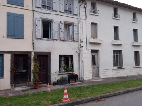 Castelnau-DurbanTiny Studio Ariège Pyrénées的一座白色的建筑,前面设有窗户和橙色锥形
