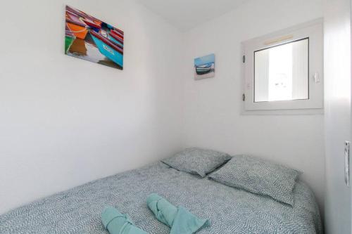 - une chambre avec un lit avec deux oreillers et une fenêtre dans l'établissement Le Jamaïque * Clim * Terrasse * Plage à 10 min, à La Grande Motte
