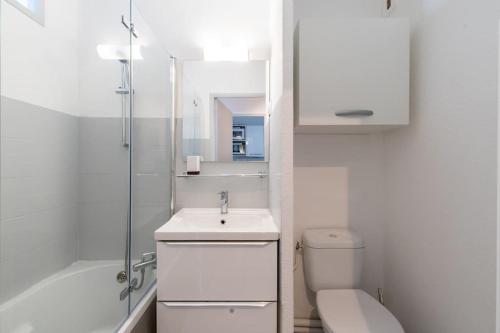 une salle de bain blanche avec des toilettes et un lavabo dans l'établissement Le Jamaïque * Clim * Terrasse * Plage à 10 min, à La Grande Motte