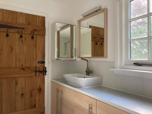 a bathroom with a sink and a mirror at Ashdown Forest character cottage, 18th Century in Crowborough