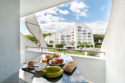 une table de petit-déjeuner sur un balcon avec vue sur un immeuble dans l'établissement Le Jamaïque * Clim * Terrasse * Plage à 10 min, à La Grande Motte