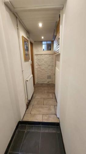 a hallway of a room with a door and a tile floor at Ashdown Forest character cottage, 18th Century in Crowborough