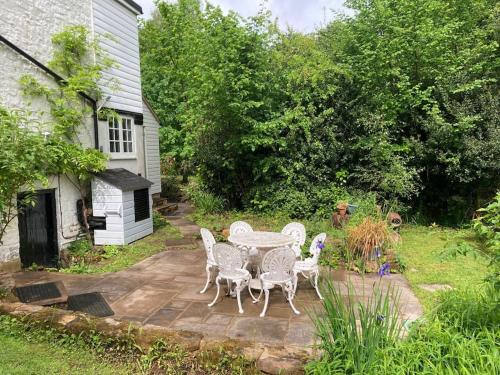 a patio with a table and chairs in front of a house at Ashdown Forest character cottage, 18th Century in Crowborough