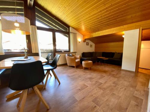 a living room with a table and chairs at AlpenApart Montafon - Haus Engstler in Schruns-Tschagguns