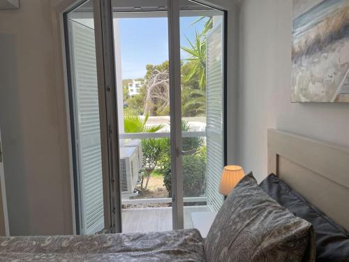 ein Wohnzimmer mit einer großen Glastür zu einer Terrasse in der Unterkunft Playa d'Or 16 / Cala D'Or / Mallorca in Cala d´Or