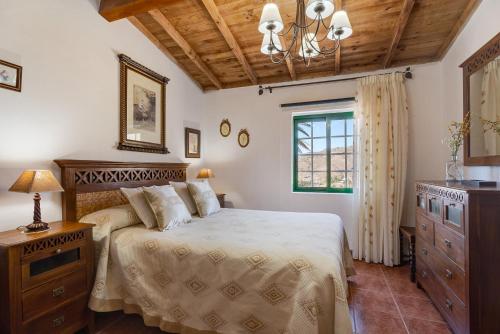 a bedroom with a bed and a dresser and a window at Rosa del Negro in Alojera