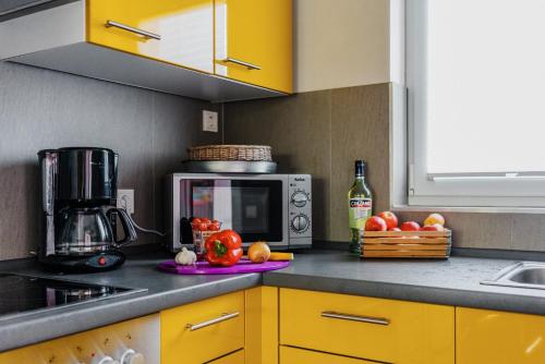 a kitchen with yellow cabinets and a microwave at Ferienhaus Hödur in Hasselfelde