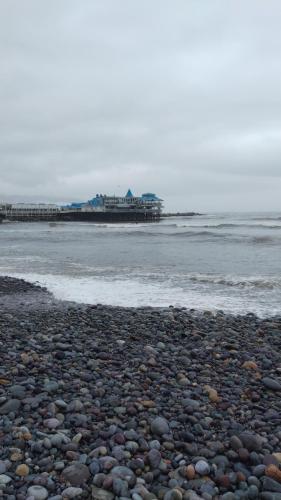 a rocky beach with a pier in the water at Centric, private, petfriendly budget apartments in Miraflores in Lima