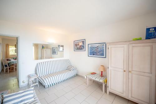 sala de estar con sofá y mesa en Romarin - Appt pour 4 voyageurs avec splendide vue mer, en Le Lavandou