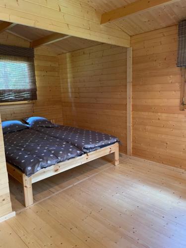 1 dormitorio con 1 cama en una habitación de madera en Dagö Berry suvemaja, en Hiiumaa