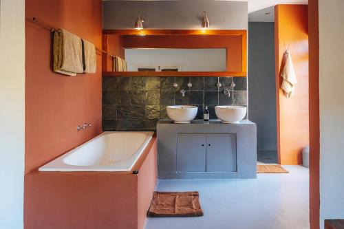 uma casa de banho com banheira e 2 lavatórios num balcão em Farm 215 Private Nature Reserve em Uilenkraal