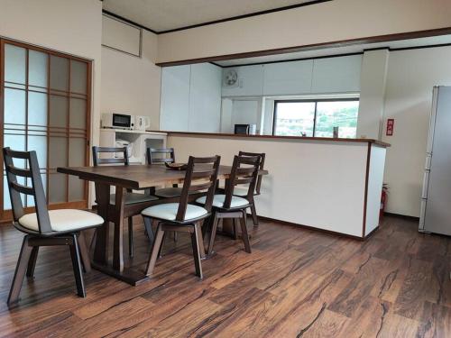 Habitación con mesa, sillas y cocina. en Cliff top Terrace, en Kuranomoto