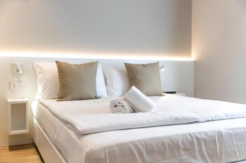a white bed with white sheets and pillows at Palazzo Betteloni in Bardolino