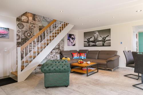 a living room with a couch and a staircase at Premium-Plus-Ferienhaus Havanna Select in Hasselfelde