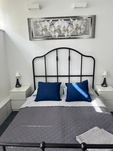 a bedroom with a large bed with blue pillows at Coser Apartamenty Centrum in Warsaw
