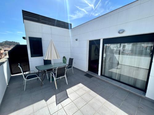 a patio with a table and chairs on a balcony at Apartamentos TDM in Tossa de Mar