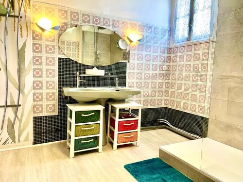 baño con lavabo y espejo en la pared en Maison B, en Bergerac