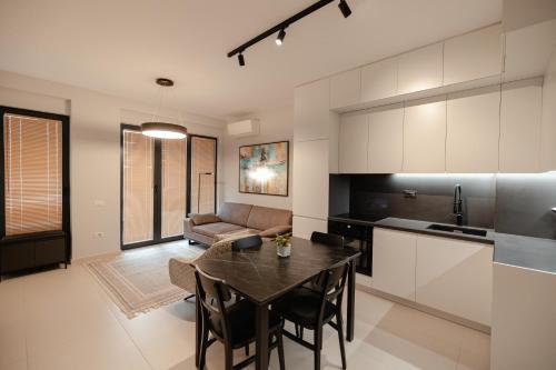 a kitchen and living room with a table and a couch at Babbo in Vlorë