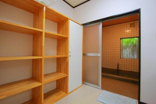 Family Ryokan Kawakyu with Showa Retro, private hot spring في إيبوسوكي: غرفة بأرفف خشبية وباب زجاجي