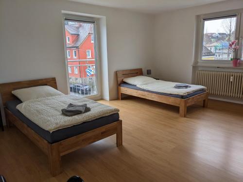 two beds in a room with two windows at Monteurunterkunft Windischeschenbach by HausGruenerBaum in Windischeschenbach