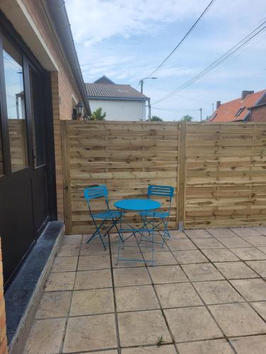 a patio with two chairs and a table and a fence at Studio proche gare TGV Haute Picardie in Dompierre-Becquincourt