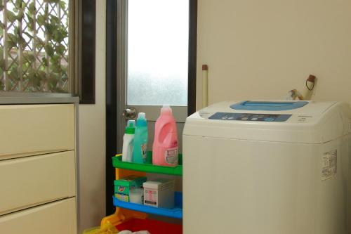 a kitchen with a washing machine with detergents at Family Ryokan Kawakyu with Showa Retro, private hot spring in Ibusuki