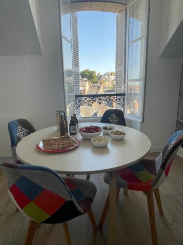 a table with food on it with chairs and a window at Spacieux appartement à Blois avec Wifi gratuit in Blois