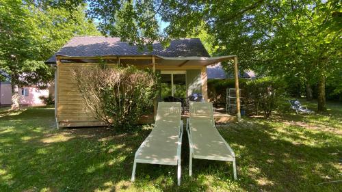 a table and two chairs in front of a house at Village 17 gites, Piscine, Restaurant , 2 gites avec SPA, 3km de Conques in Conques