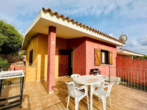 a patio with a table and chairs and a house at Oleandro, Rena Majore in Rena Majore