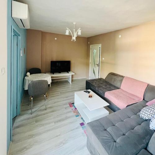 a living room with a couch and a tv at Midtown Apartment in Kŭrdzhali